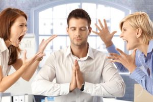Meditating closed eye businessman in office with arguing colleagues shouting and fighting.